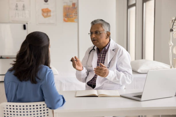 istock Indian male doctor asks patient about symptoms during visit 2195531484