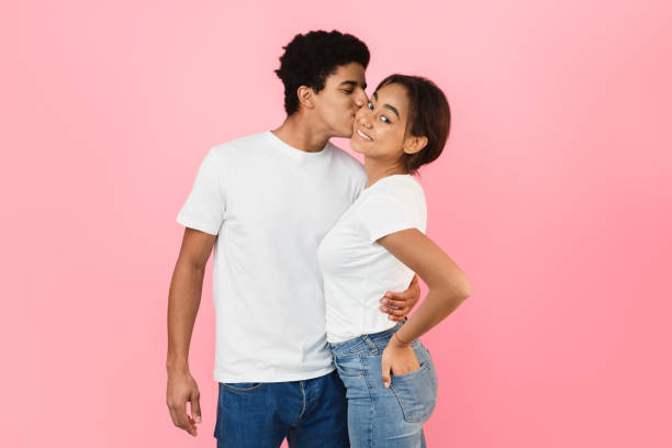 istock Handsome guy hugging girlfriend and kissing her in cheek 2195534472