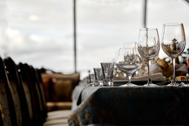 A sophisticated dining setup with elegant glassware and a detailed tablecloth, set against a scenic window view, perfect for upscale gatherings or formal occasions..