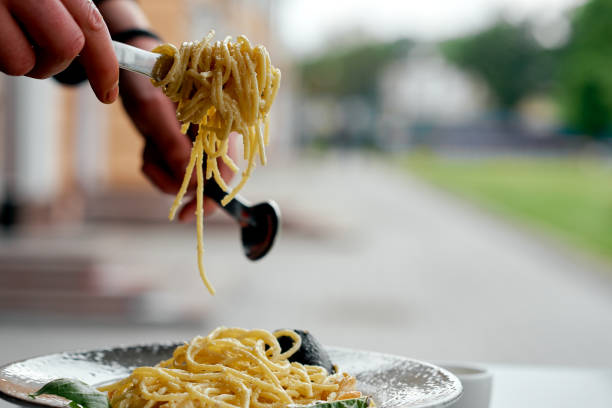Hands Lifting Creamy Seafood Spaghetti.