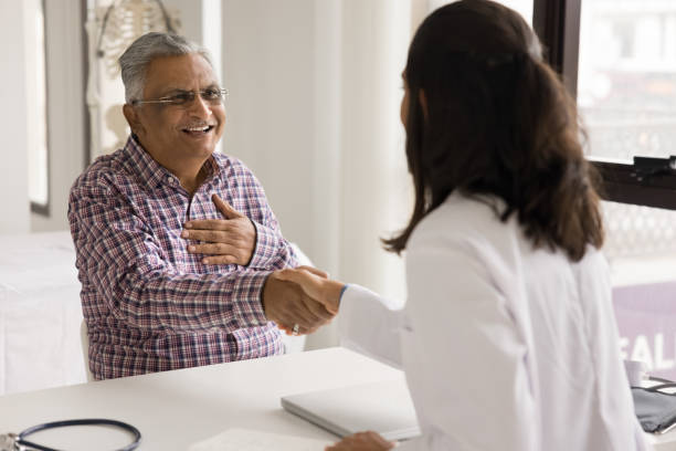 istock Older patient and young female general practitioner shaking hands 2195535929