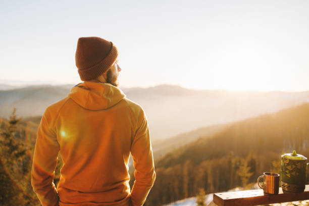 Serene man njoys scenic sunset in the mountians