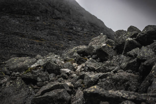istock Dramatic rocky slope surrounded by fog under a moody overcast sky 2195539845