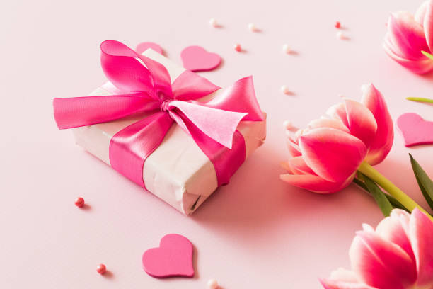 istock Pink tulips and hearts, gift box with ribbon on light pink background 2195543564