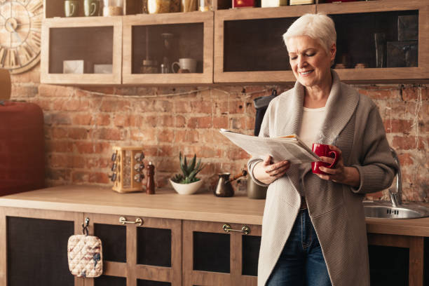 Elderly Woman Enjoys Morning Coffee While Reading Newspaper in Cozy Kitchen With Rustic Decor