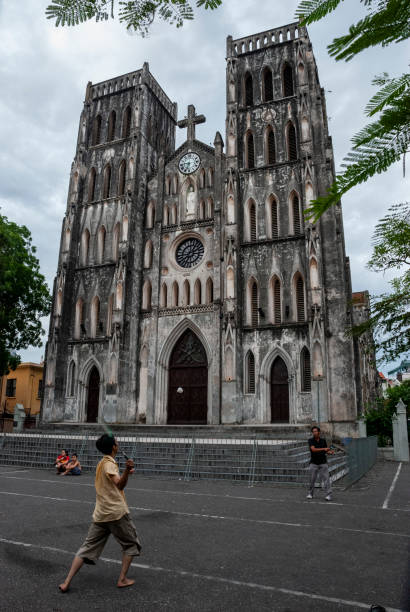 Men play badminton shortly after sunrise outside  St. Joseph Cathedral in Hanoi, Vietnam (July 19, 2007)