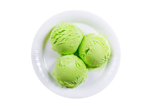 plate of kiwi ice cream scoops isolated on white background, top view