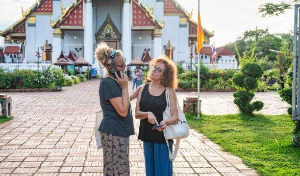 istock Two tourists checking information on a phone while standing in front of a traditional temple in Ayutthaya, Thailand 2195552630