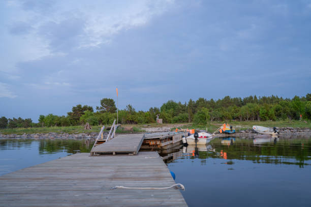Fishing boats with net flags by the pier. Fishing boat pier and boats on the seashore at evening.