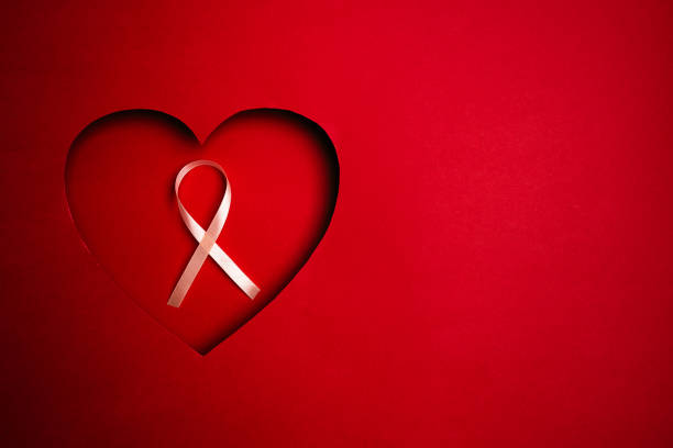 Pink Breast Cancer Awareness Ribbon. Flying pink ribbons in a heart on red background. Breast cancer awareness and October Pink day, world cancer day. Top view. Mock up.