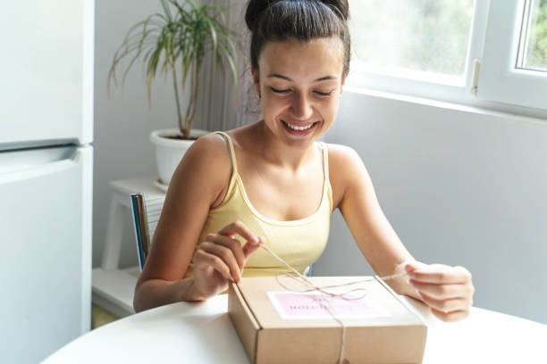 istock Young woman opening subscription box with happy smile. 2195560245