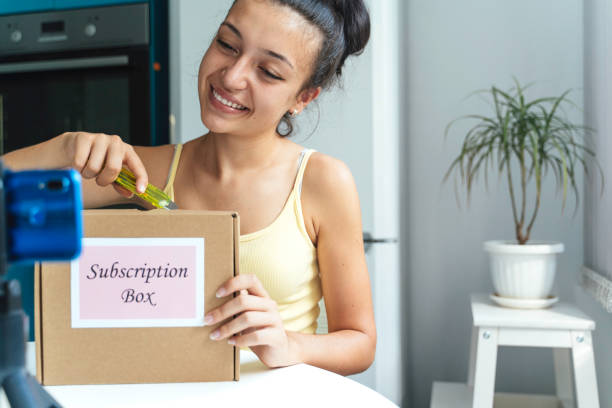 istock Young woman unboxing subscription box with excitement. 2195560277