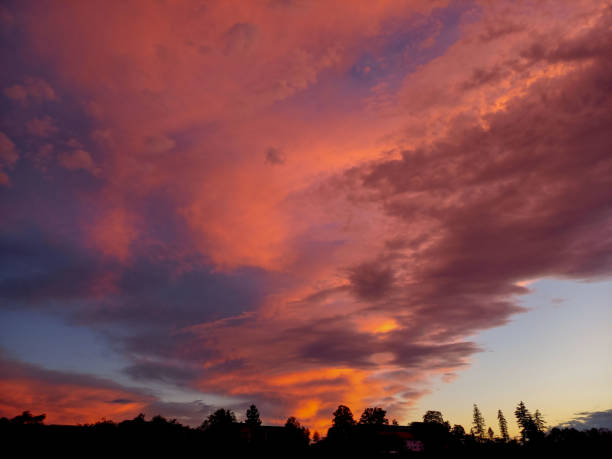 Stunning golden sunset casting warm hues over soft, billowing clouds. A serene and vibrant scene