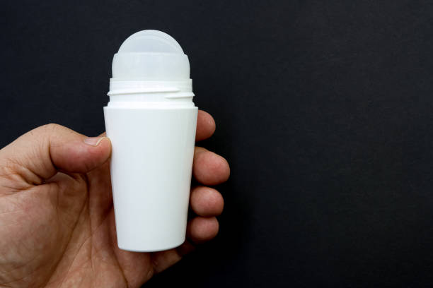 Hand with a bottle of roll-on deodorant