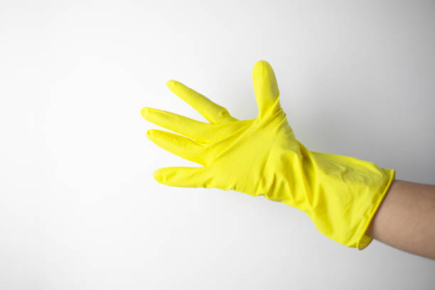 istock Housekeeping concept. Hand in yellow glove showing 2195565058