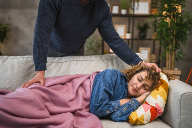 istock wife sleeps on the couch while her husband covers her with blanket 2195565846