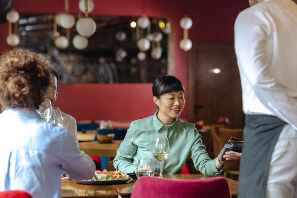 istock Woman in restaurant making payment at a modern restaurant environment 2195568848