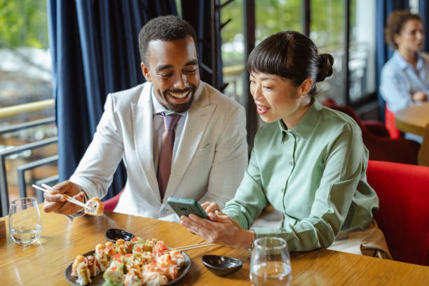 istock Two professionals enjoying a sushi meal while discussing work and using smartphone 2195569847