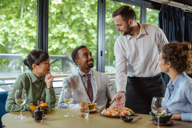istock Group enjoying a sushi  meal served by a friendly waiter in restaurant 2195570280