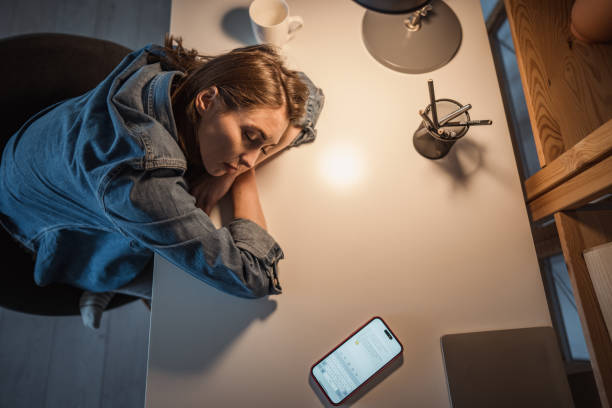 istock Exhausted woman falls asleep in her workspace 2195571022