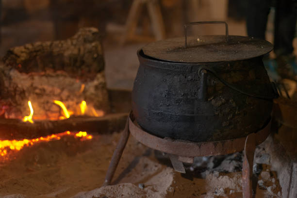 Old iron pot from the Mapuche ethnic group next to a stove with firewood