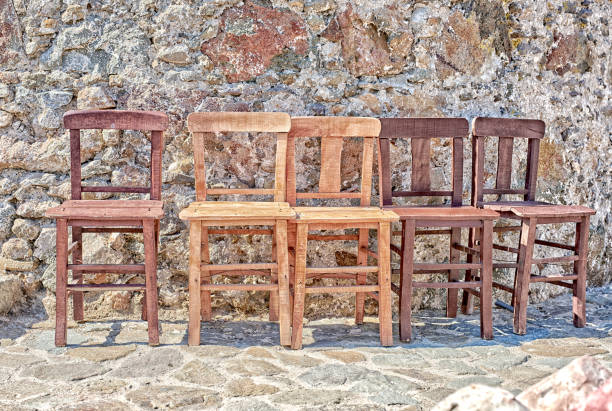 istock Rustic Wooden Chairs Against A Stone Wall in Outdoor Setting 2195579873