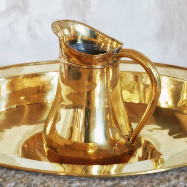 istock Shiny Golden Brass Pitcher on Reflective Circular Tray Close-Up 2195579896