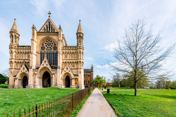 Tourists walking in verulamium park in front of st albans cathedral on a sunny spring day