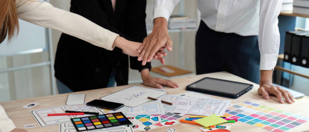 istock United UX UI design team placing hands together in support during a collaborative project session 2195592580