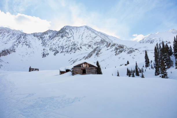 Aerial view of man and mountain hut in snowstorm, backcountry ski trip, British Columbia