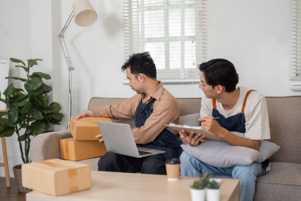 istock Business partners discussing ecommerce strategy while unpacking boxes at home office 2195593725