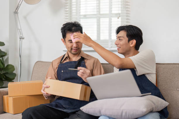 istock Business partners playfully discussing ecommerce logistics while unboxing in their home office 2195593777