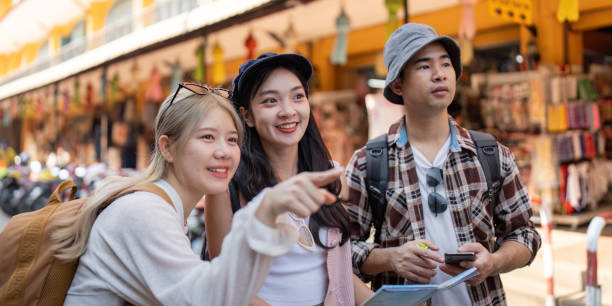 istock Friends navigating a vibrant market, excitedly discussing plans while traveling and exploring new experiences 2195594844