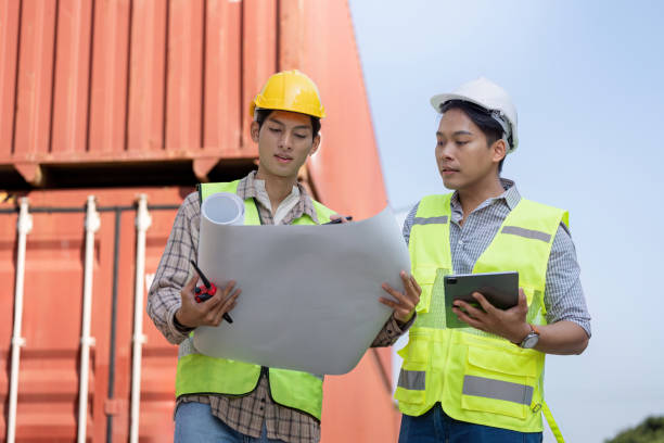 istock Engineers reviewing blueprints for logistics and container management in import and export 2195597043