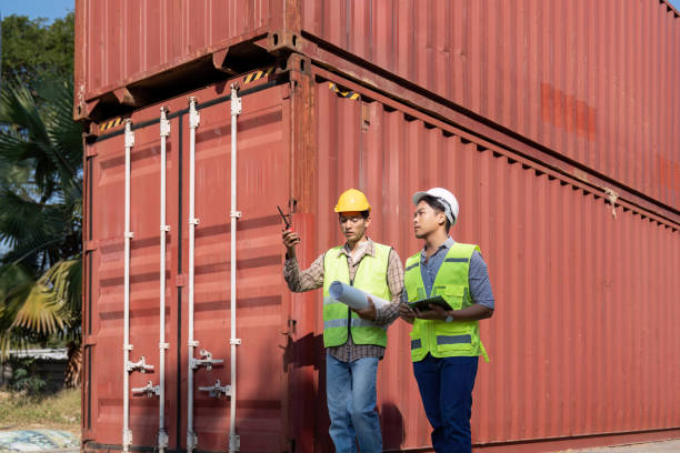 istock Engineers discussing plans for logistics and container management near shipping containers 2195597081