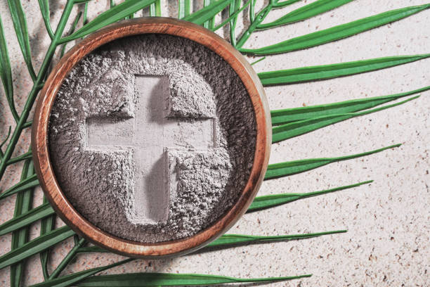 istock Ash Wednesday. Cross in ashes on a palm leaf background 2195600156