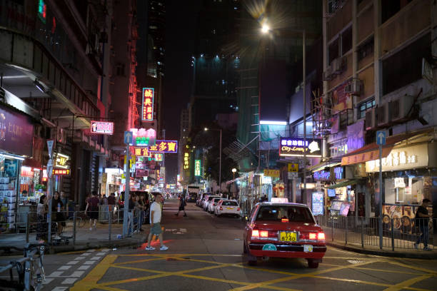 People walking on a street in Mongkok district by night, Kowloon Peninsula. The area, with its extremely high population density of 130,000/km2 was described as the busiest district in the world. Hong Kong