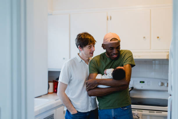 istock Two Dads Preparing Bottle for Their Baby Together 2195608977