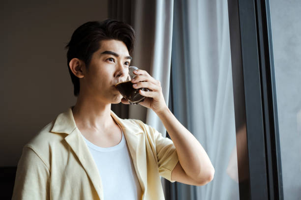 istock Asian young man enjoying coffee in the house. 2195611314