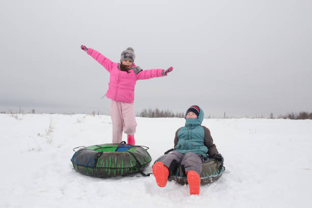 istock children ride down an ice slide 2195611771