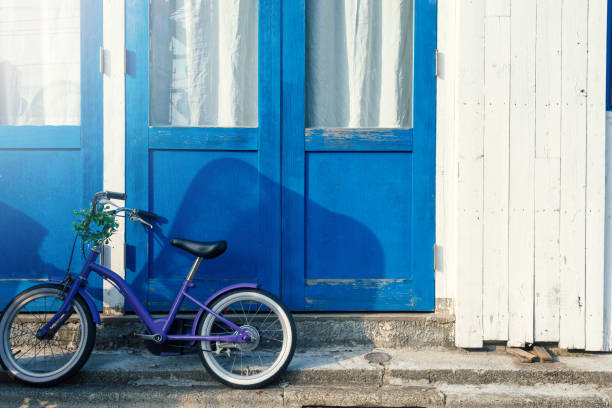A cafe with a blue door and a blue bicycle, on a street corner in Tokyo.