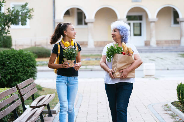 istock Two people walking outside carrying groceries together 2195613179