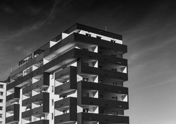 A contemporary condominium stands tall against a darkened sky, highlighting urban living contrasts.