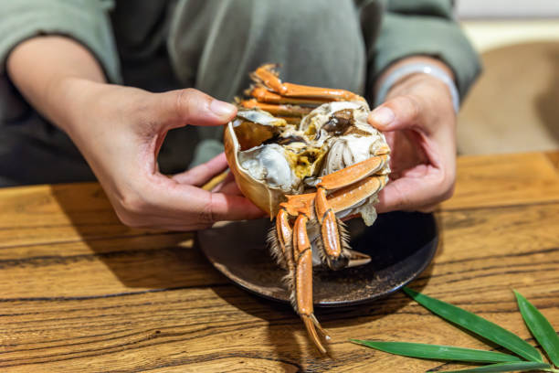 A woman's hand showing a peeled hairy crab