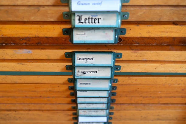 Closeup of vintage labeled compartments showcasing organization of printing tools and letter samples