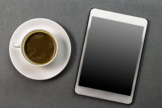 černá káva a tablet na šedém stole - pružnost vytrvalostí fotky - stock snímky, obrázky a fotky