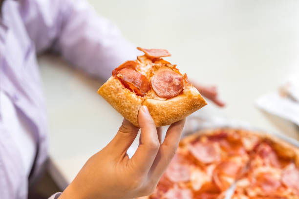istock close-up eating sausage pizza with no face 2195618953