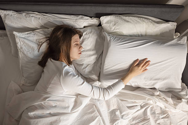 istock Woman Experiencing Loss In Bedroom Touching Pillow 2195619321