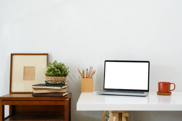 istock Creative workspace with blank screen laptop, coffee mug and picture frame 2195619677