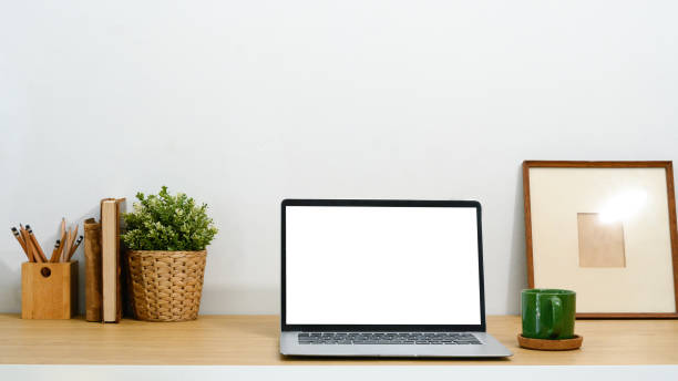 istock Minimalist workspace with blank screen laptop, a green coffee mug and potted plant 2195619692